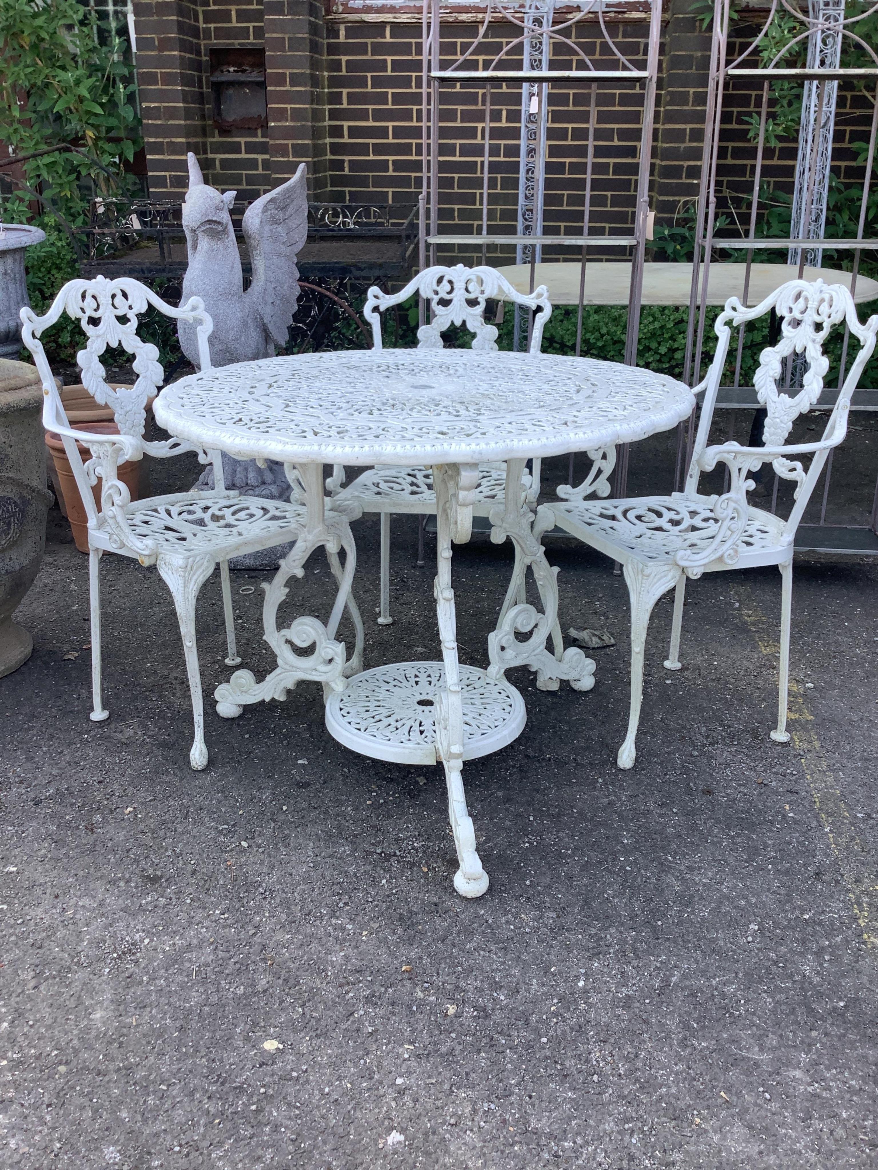 A Victorian style white painted circular aluminium garden table, diameter 90cm, height 72cm and six matching elbow chairs